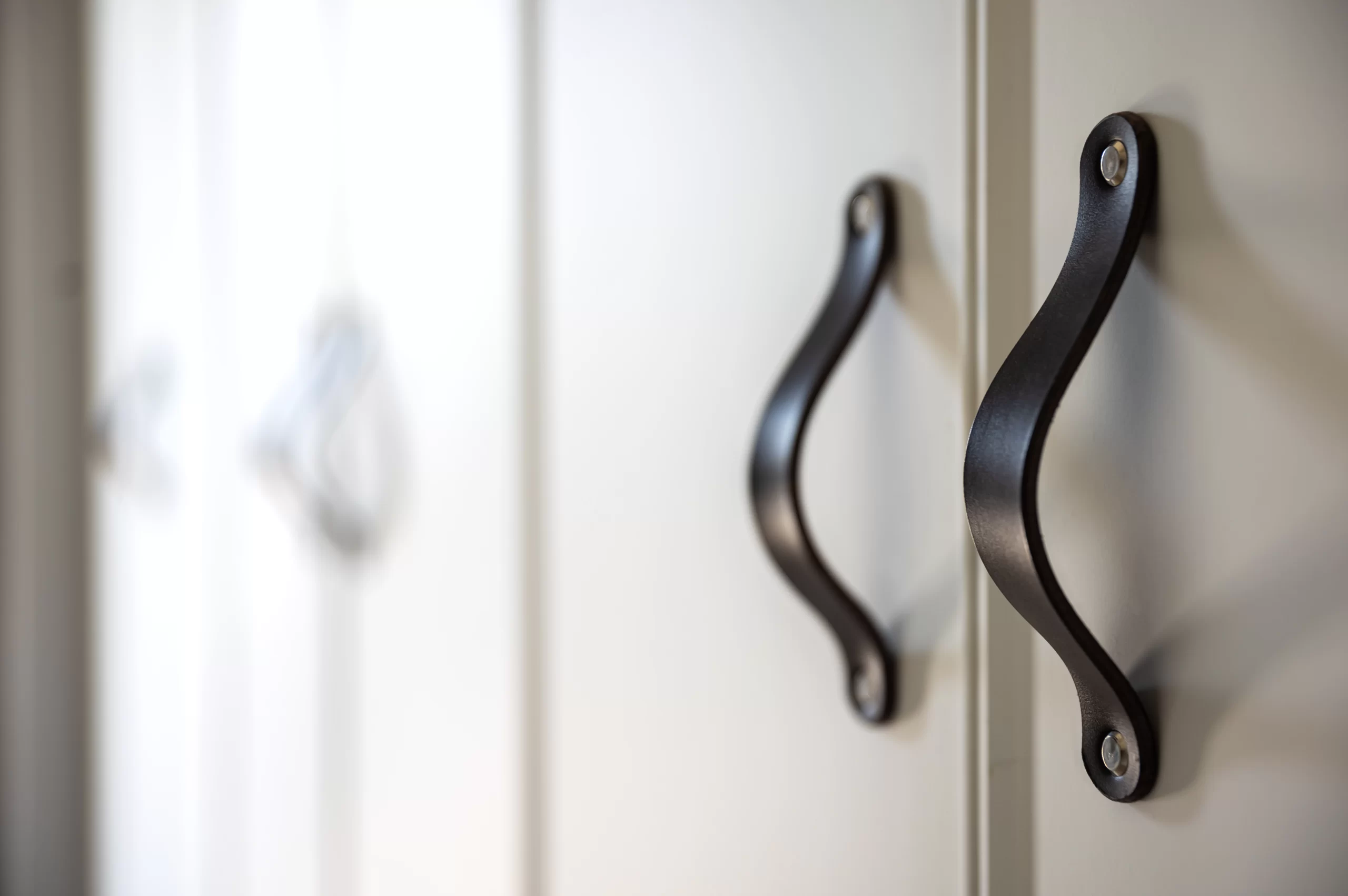 Matte black cabinet pulls installed on custom shaker-style cabinet doors in a modern kitchen, courtesy of True North Cabinetry.